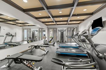 A gym with treadmills, exercise bikes, and other equipment.