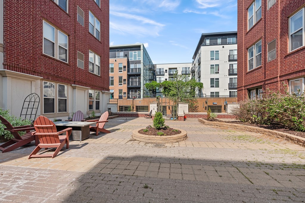 A courtyard with a circular garden and chairs.