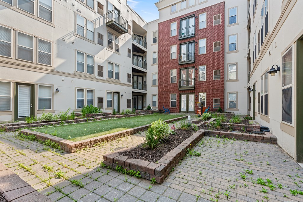 A courtyard with a brick wall and a small garden.