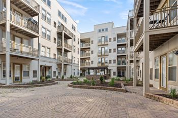 A courtyard surrounded by apartment buildings with a clear blue sky.