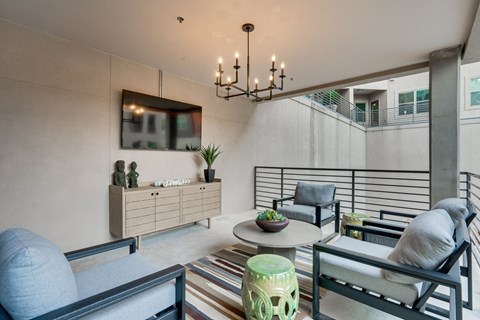 A modern living room with a striped rug and a black chair.