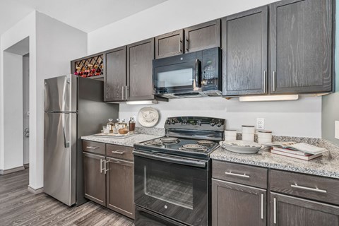 A kitchen with dark wood cabinets and stainless steel appliances.