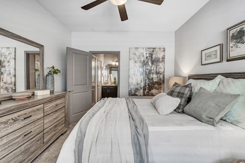 A bedroom with a large bed and a ceiling fan.