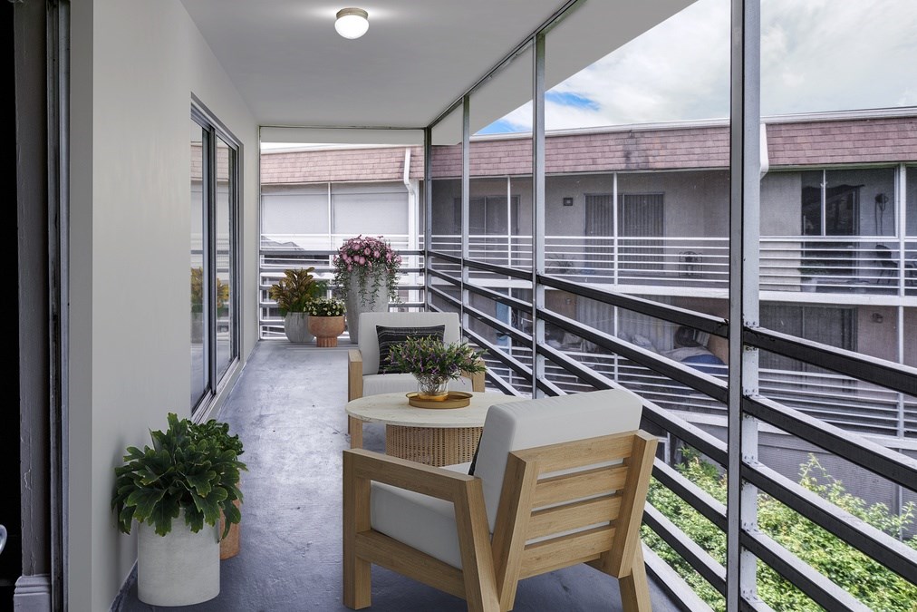 Outdoor screened patio with seating at Coronado Springs Apartments in Palm Springs, FL. Pet-friendly one- and two-bedroom homes with private balconies and relaxing spaces.