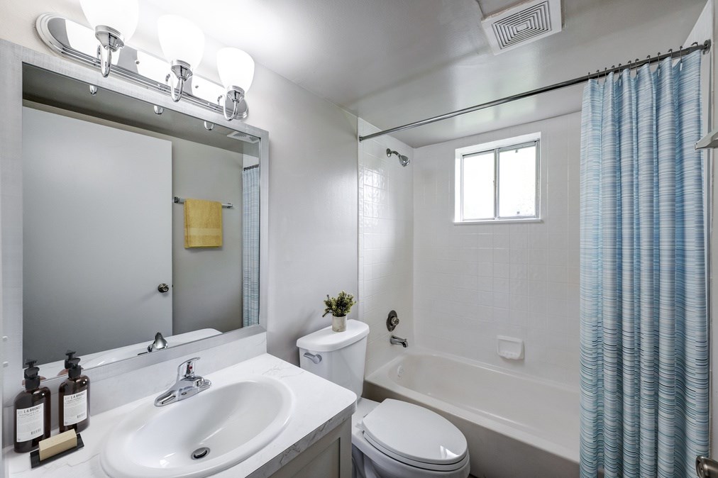 Bright bathroom with tub and shower combination at Coronado Springs Apartments in Palm Springs, FL. Modern fixtures in a pet-friendly apartment home.