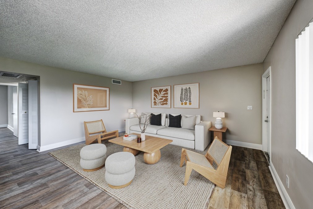 Open living area with wood-style flooring and large windows at Coronado Springs Apartments in Palm Springs, FL. Pet-friendly one- and two-bedroom apartments for rent.