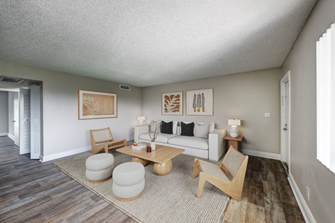 A living room with a white couch, a wooden coffee table, and a rug.