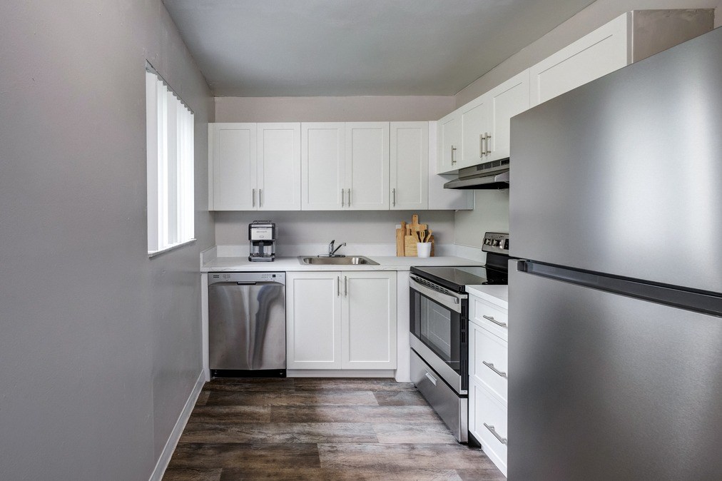 updated kitchen with stainless-style appliances and modern cabinetry at Coronado Springs Apartments in Palm Springs, FL. Spacious pet-friendly apartment home.