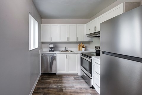 A kitchen with white cabinets and stainless steel appliances.
