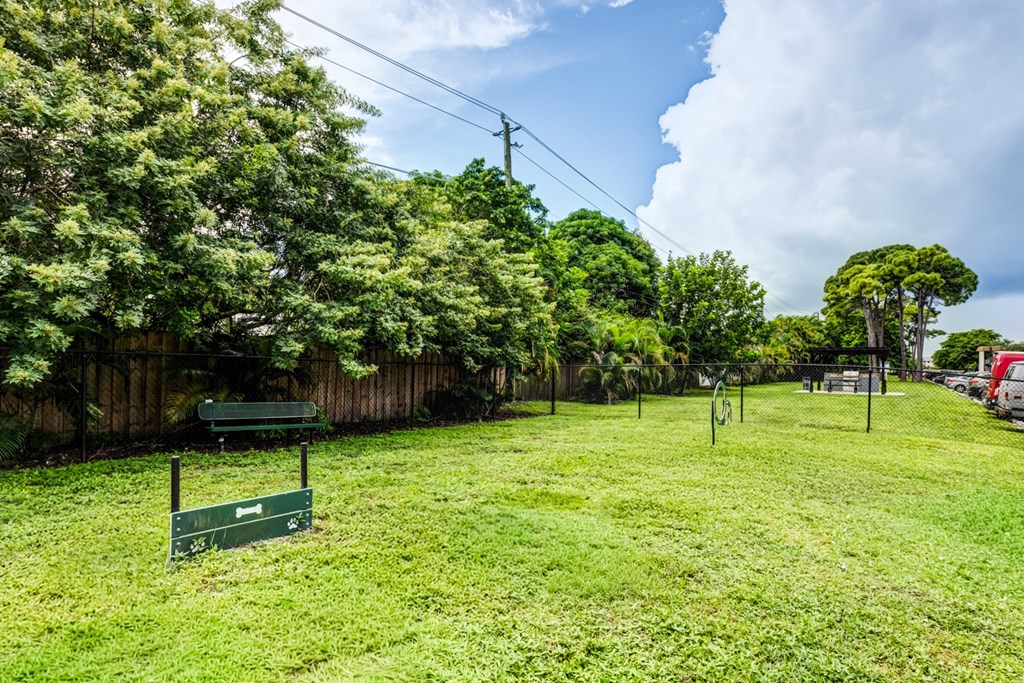 Fenced dog park at Coronado Springs East Apartments in Palm Springs, Florida, offering a leash-free area for pets to play within this pet-friendly community