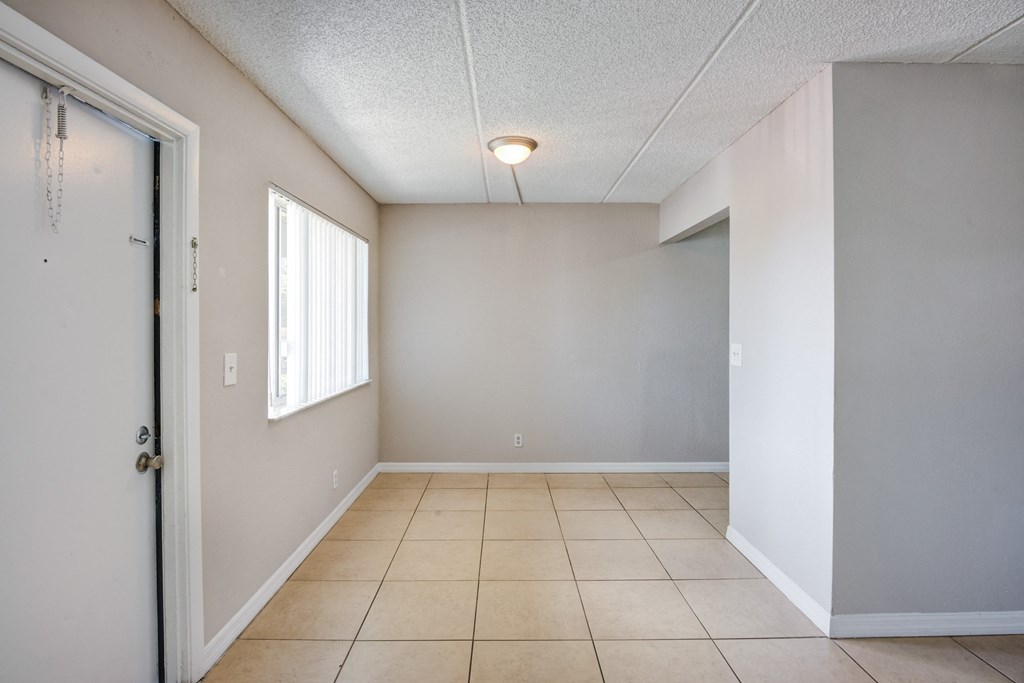 the living room and dining room of an empty apartment