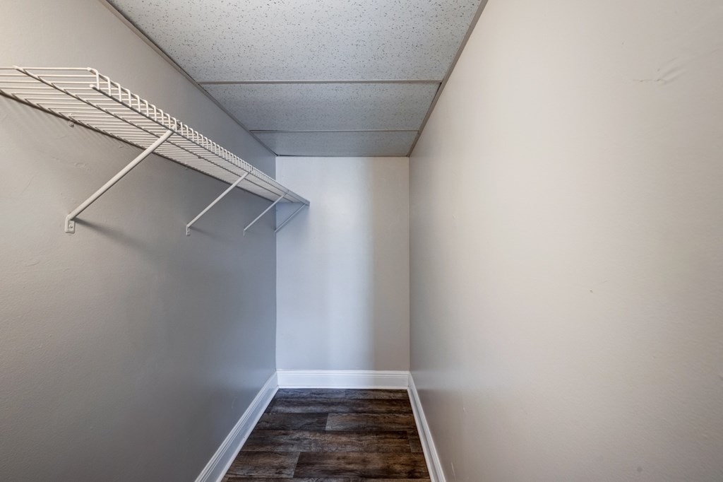 Spacious walk-in closet with shelving inside a renovated 1- or 2-bedroom apartment at Coronado Springs East in Palm Springs, Florida, a pet-friendly apartment community.