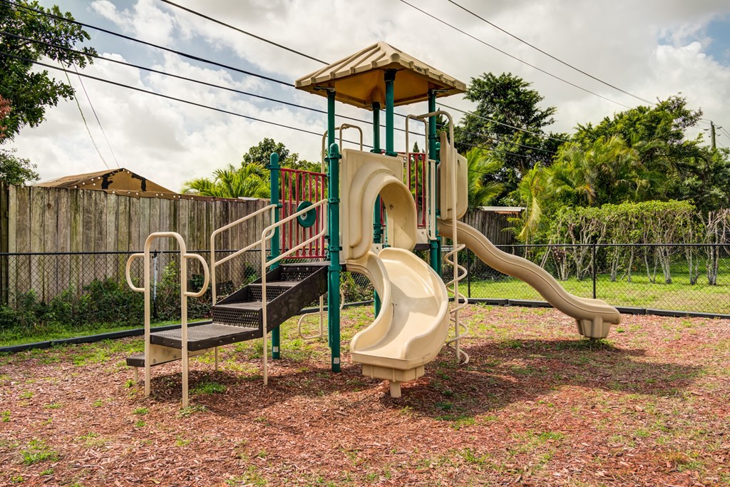 a playground with a jungle gym and slides in a backyard