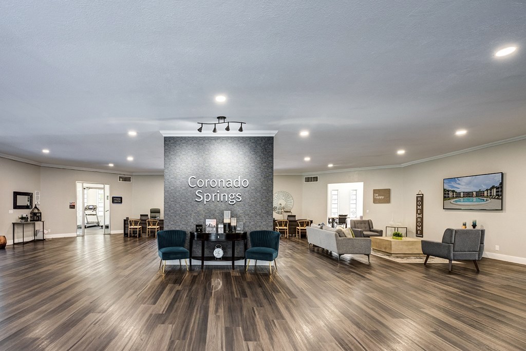 Leasing office and resident lounge at Coronado Springs Apartments in Palm Springs, FL, featuring modern wood-style flooring and welcoming seating in a pet-friendly community.
