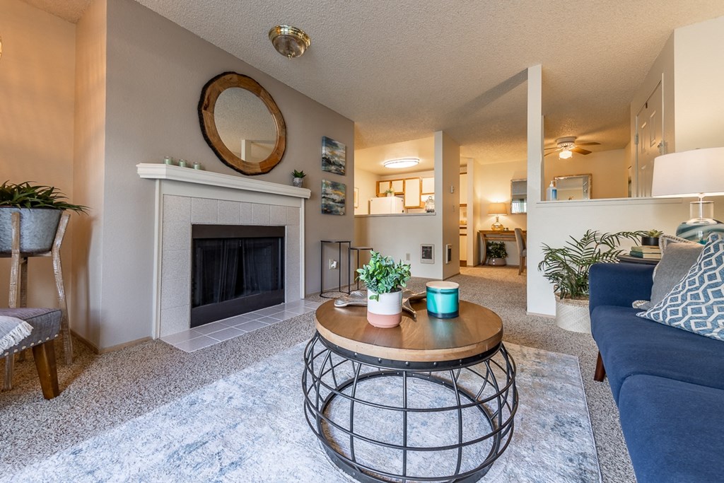 Dog-Friendly Apartments In Kent - Country Glen - A Bright Living Room With A Comfortable Sofa, Plants, Table Lamps, A Sliding Glass Door, And Carpet Flooring.