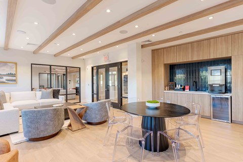 Resident lounge at Creekline at Fairfield apartments in Fairfield, CT featuring cozy seating, a community kitchenette, and a coffee/espresso machine station.
