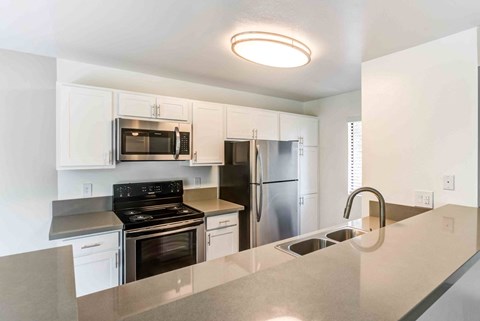 A kitchen with white cabinets and stainless steel appliances.