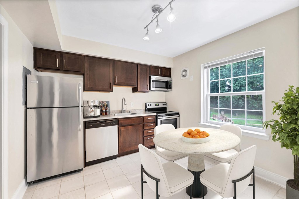 a kitchen with stainless steel appliances and a table with chairs