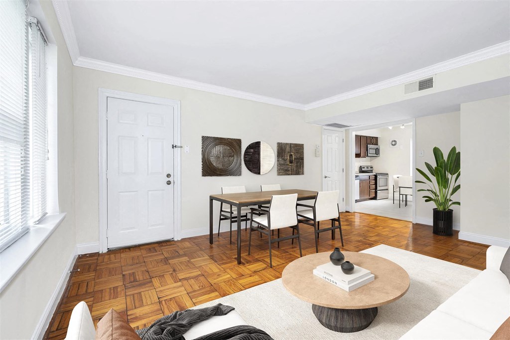 the living room and dining room of a house with a table and chairs