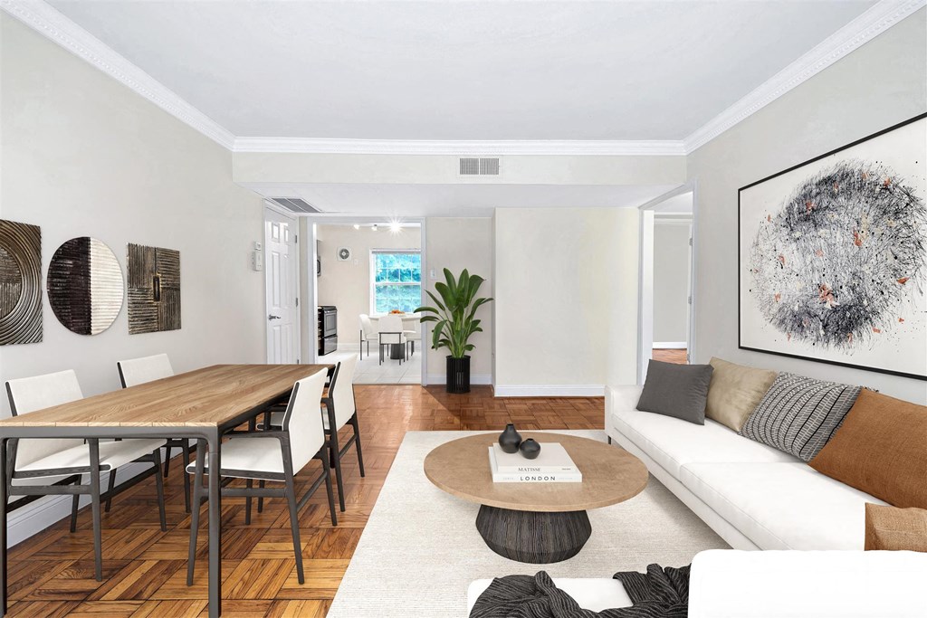 an open living room and dining room with white furniture and a wooden table