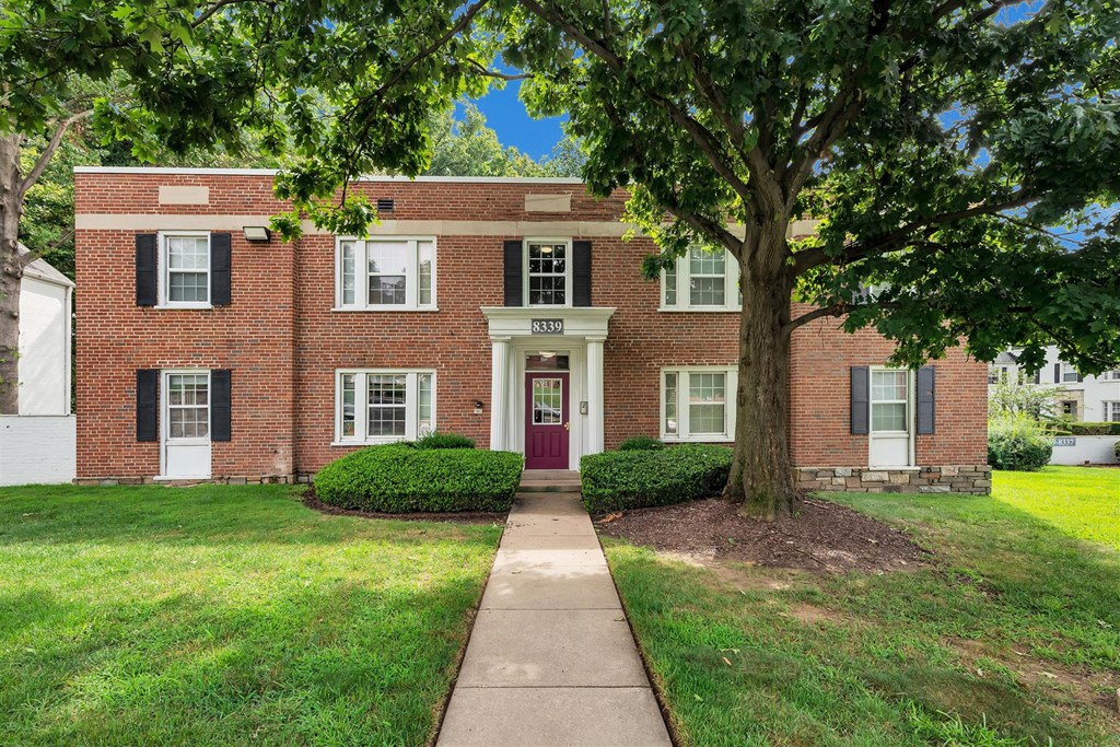 a red brick building with a sidewalk in front of it
