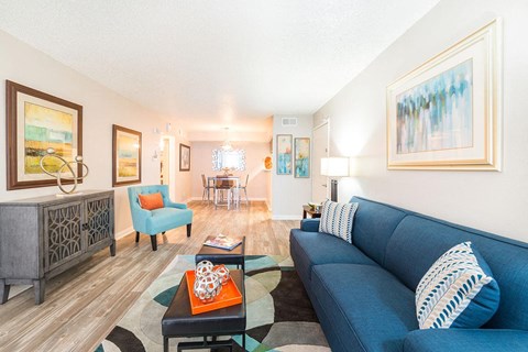 A living room with a blue couch and a wooden cabinet.