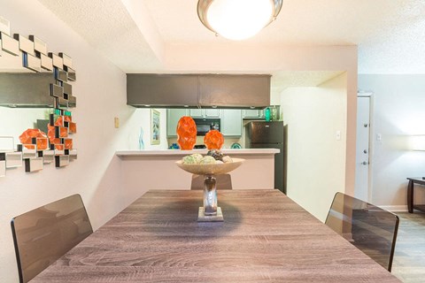 a dining room table with a kitchen in the background