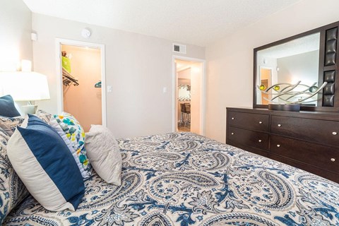 a bedroom with a bed and a mirror