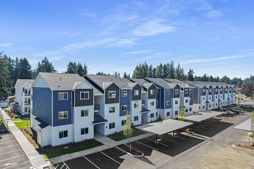 an aerial view of a row of multicolored apartment buildings with trees in the background,