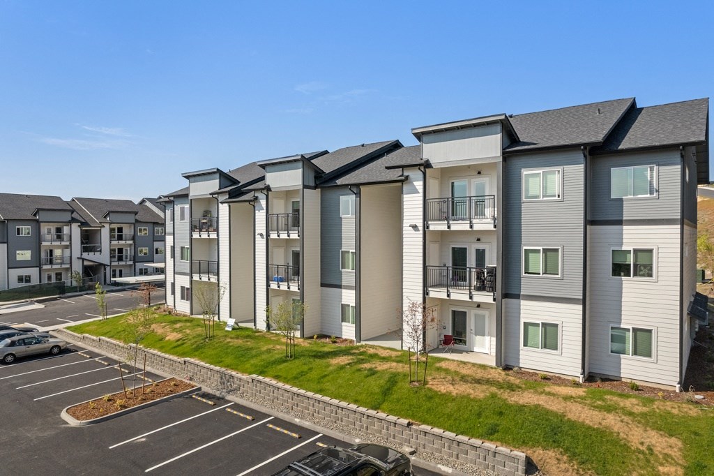 a row of apartment buildings in a parking lot,