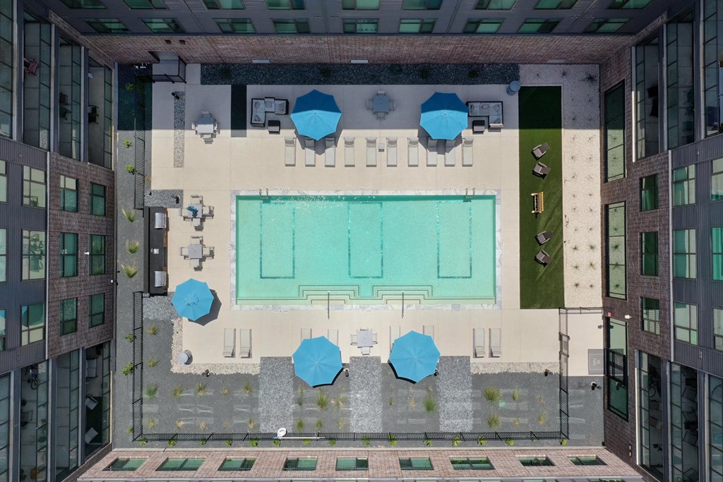 A pool surrounded by blue tables and chairs.