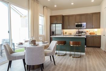 A modern kitchen with a dining table set for two.