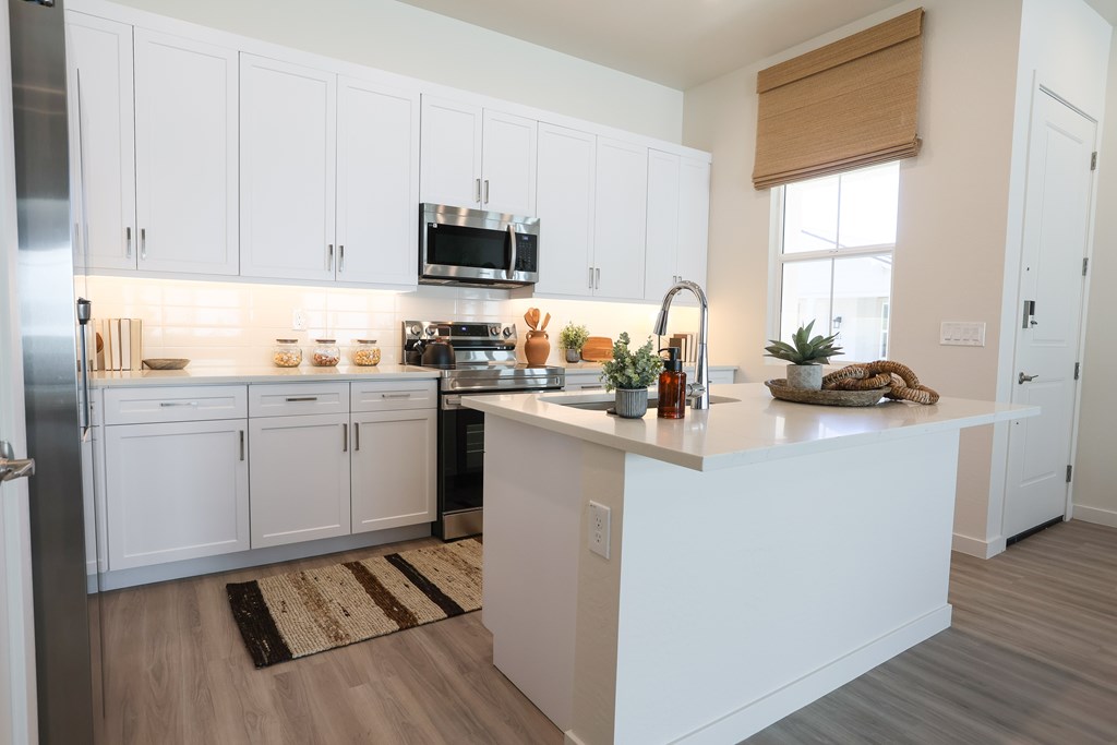 A kitchen with white cabinets and a wooden countertop.