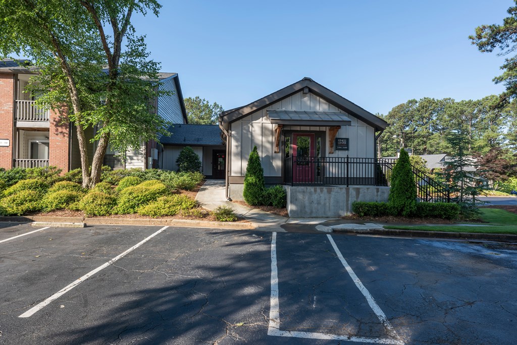 an empty parking lot in front of a house with a porch
