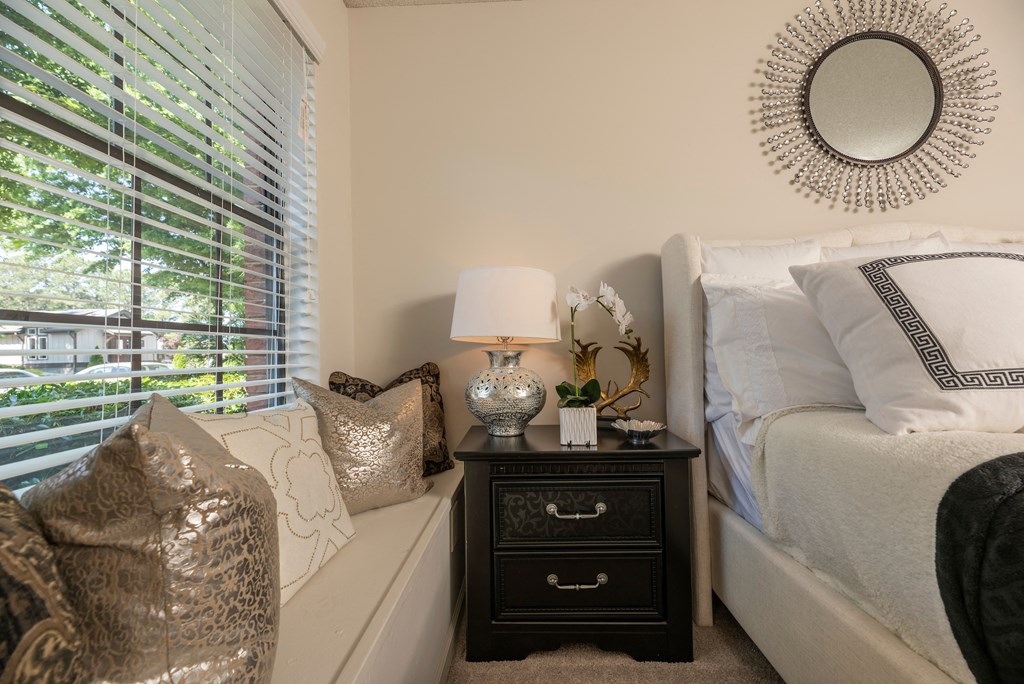 a bedroom with a bed and a nightstand and a window