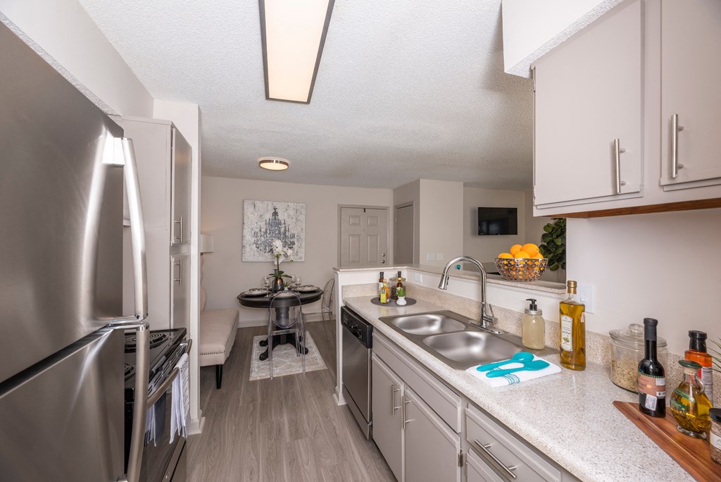 a renovated kitchen with stainless steel appliances and white cabinets