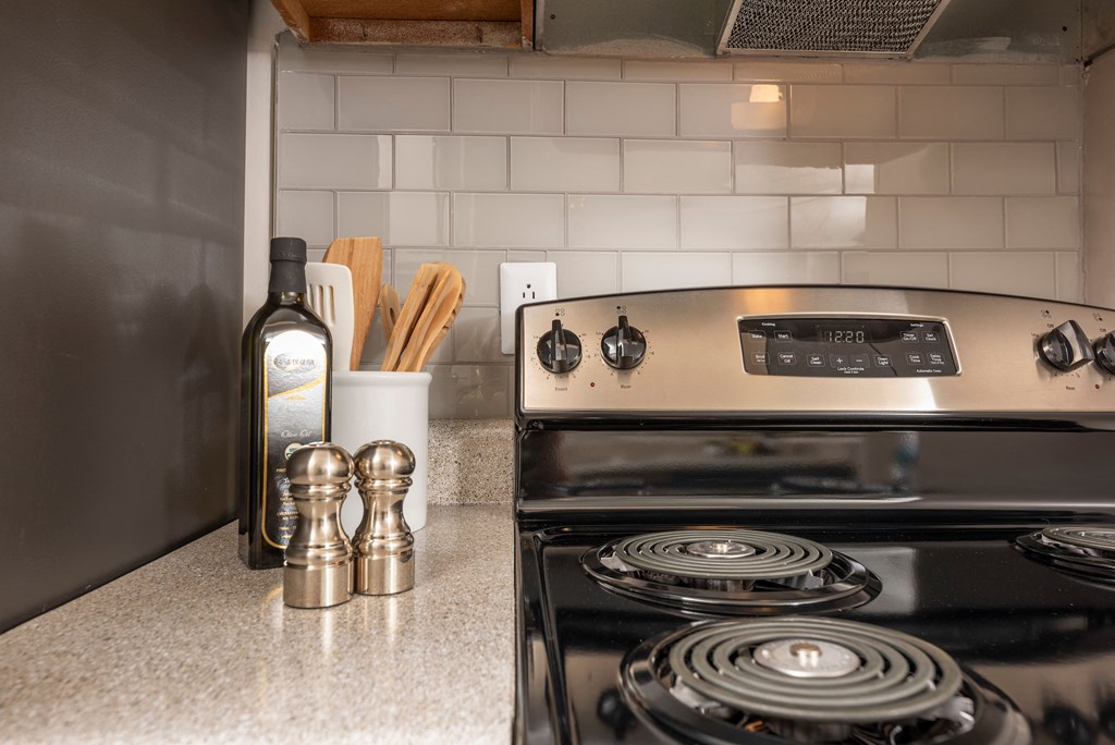 a kitchen with a stove and a bottle of wine on the counter