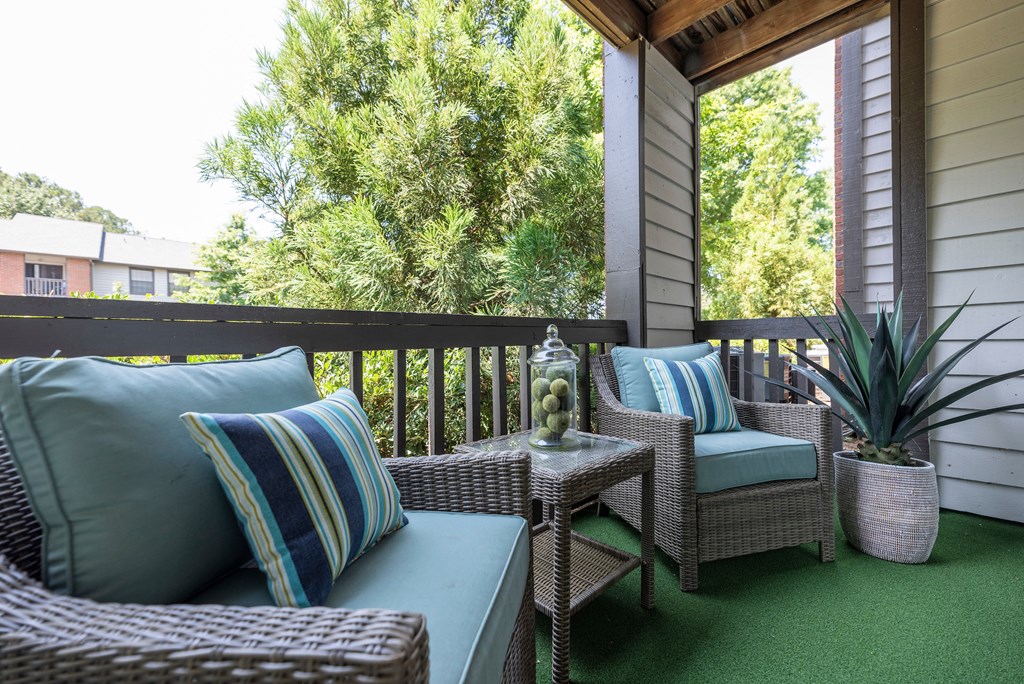 a covered porch with wicker furniture and a window