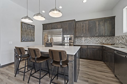 a kitchen with a marble counter top and wooden cabinets