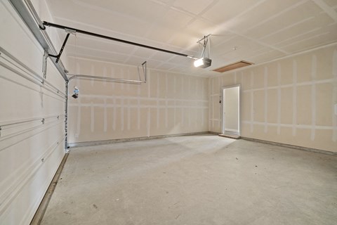 the interior of a garage with a white wall and a door