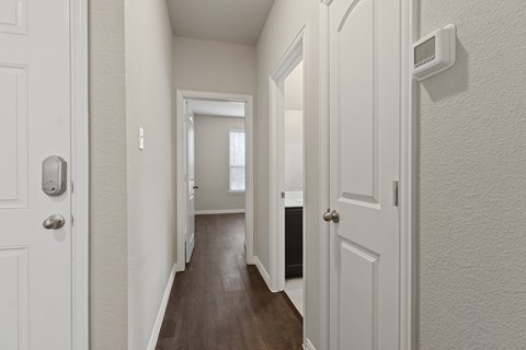 a hallway with a door open to a bedroom and a bathroom