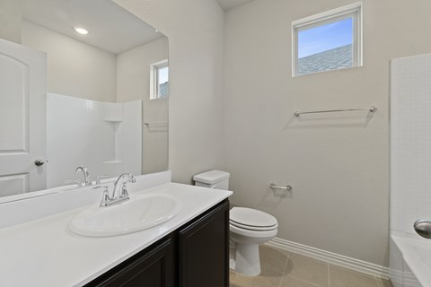 Apartments in Lewisville, TX - The Villas at Rockbrook - Bathroom with a Large Mirror and Granite Countertop.