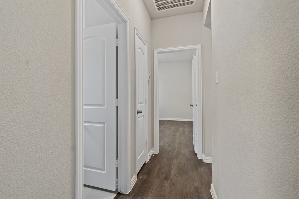 our apartments have a spacious hallway with wood flooring and white doors