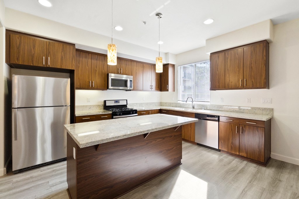 a kitchen with white countertops and wooden cabinets