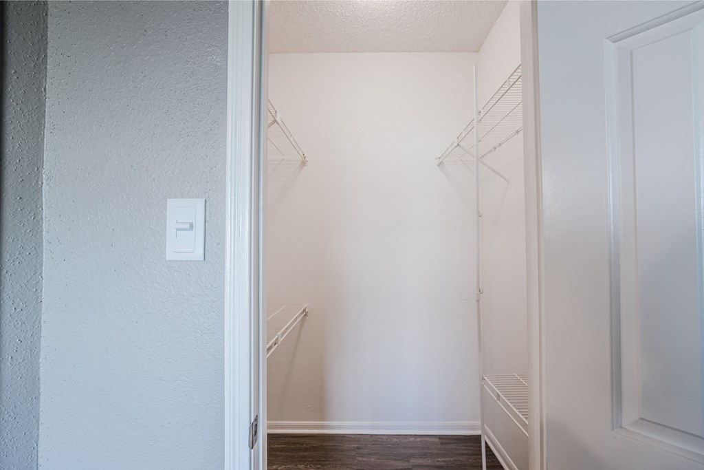 a walk in closet with white walls and a white door