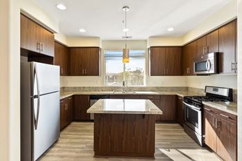 a kitchen with wooden cabinets and an island with a white countertop