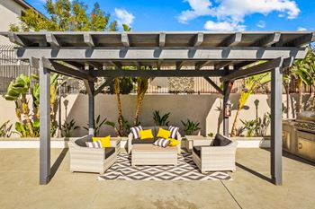 a patio with a pergola and furniture