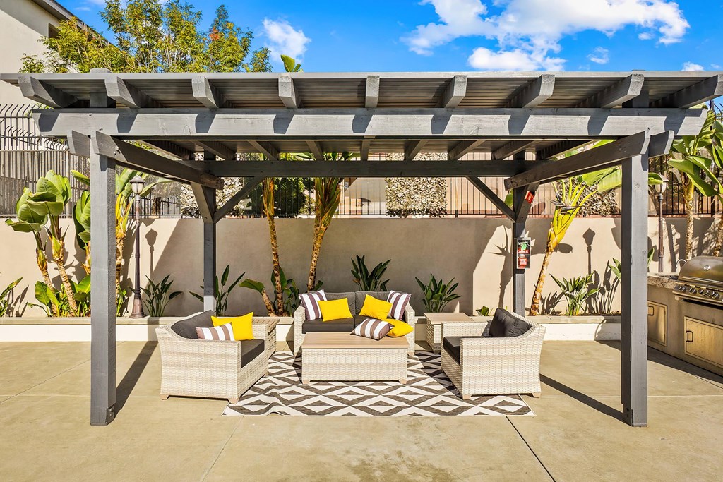 a patio with a pergola and furniture