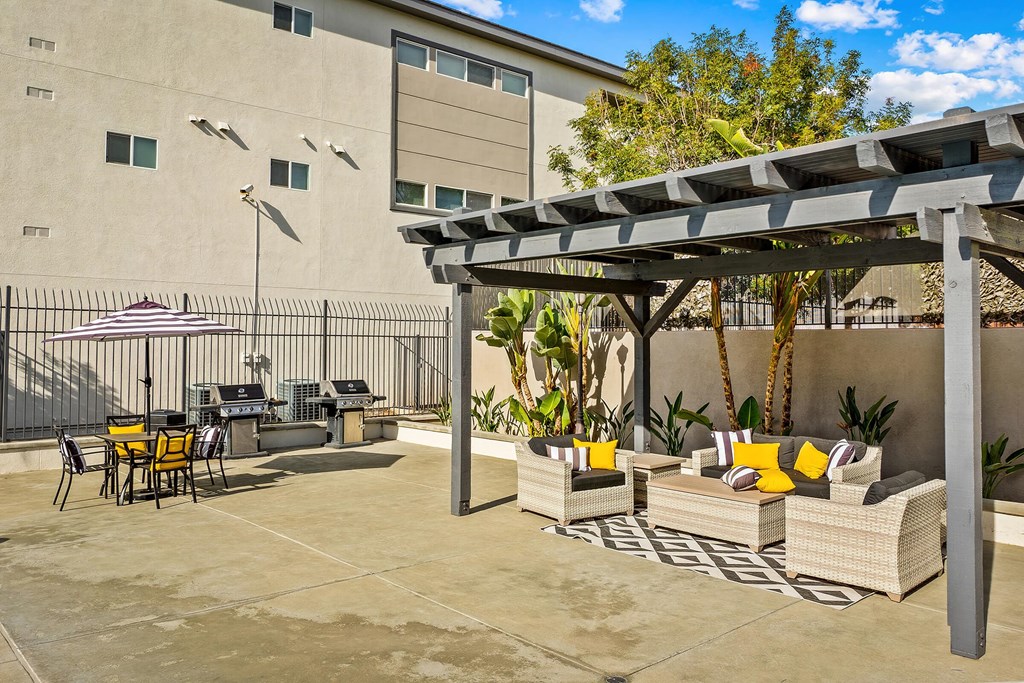 Luxury Apartments for Rent in Riverside, CA- LuxLiv- BBQ Area with Two Grill Stations, Picnic Table, and Pergola with Additional Lounge Seating