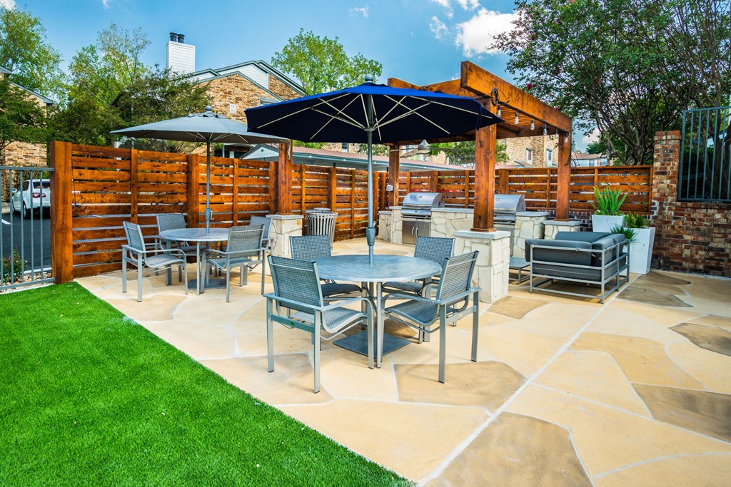 a patio with tables and chairs and umbrellas